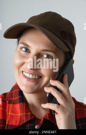 Close up portrait of woman in cap talking on the phone Stock Photo