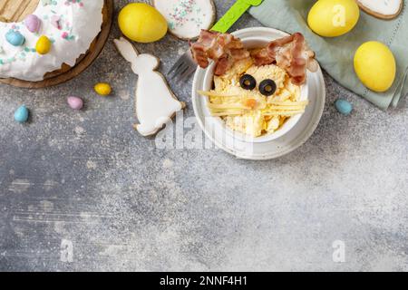 Easter breakfast idea. Scrambled eggs easter bunny on a stone background. View from above. Copy space. Stock Photo