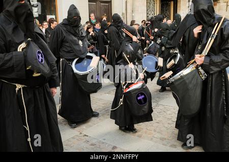 Holy Week in Zamora, Spain, procession of the Virgin of Solitude, little penitent plays the drum among his older companions. Stock Photo