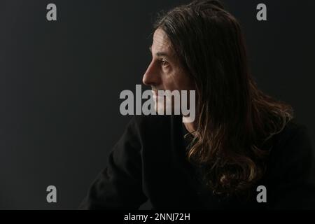 Portrait of middle aged man with long hair on black background Stock Photo