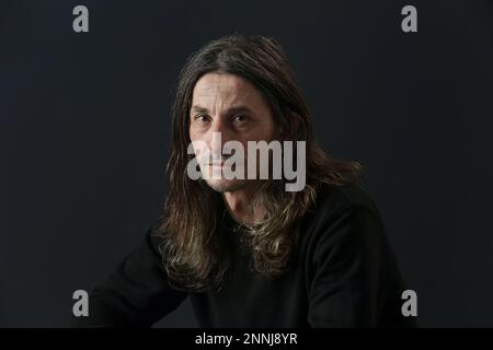 Portrait of middle aged man with long hair on black background Stock Photo