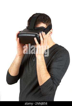 A young man with a virtual reality helmet on his head. The figure is isolated on a white background. Stock Photo