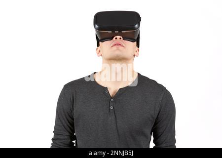 A young man with a virtual reality helmet on his head. The figure is isolated on a white background. Stock Photo