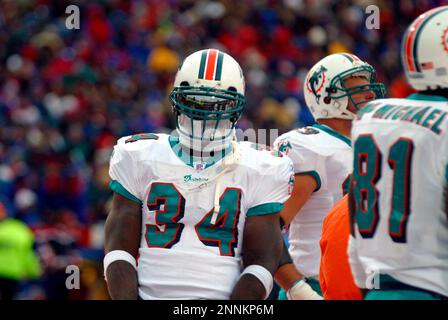 Miami Dolphins running back Ricky Williams (34) slides around Chicago Bears  linebacker Mike Caldwell (55) during the first half of the Monday, Dec. 9,  2002, game in Miami. (AP Photo/Gary I. Rothstein