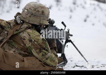 A U.S. Army paratrooper assigned to the 3rd Battalion, 509th Parachute Infantry Regiment, 2nd Infantry Brigade Combat Team (Airborne), 11th Airborne Division, “Arctic Angels,” provides fire support with the M249 machine gun while assaulting his objective during a combined arms live-fire exercise at the infantry squad battle course on Joint Base Elmendorf-Richardson, Alaska, Feb. 22, 2023. The training was held to prepare for Joint Pacific Multinational Readiness Center 23-02 and focused on large-scale combat operations, including situational training exercises and live fire exercises aimed at Stock Photo