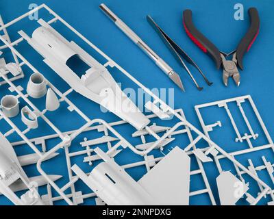 Parts and subassemblies of model aircraft and tools for their joining, close up. The assembly of a plastic model airplane Stock Photo