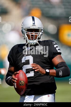 Oakland Raiders QB JaMarcus Russell (2) throws a pass with San Diego  Chargers Larry English holding his legs at the Oakland Coliseum in Oakland,  California on September 14, 2009. The Chargers defeated