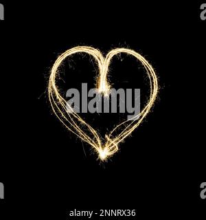 heart shape light painting with sparklers isolated on black background - symbol for love and romance Stock Photo