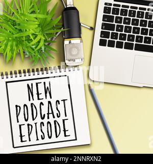 top view of words NEW PODCAST EPISODE written on spiral notepad on desk with microphone, laptop and potted plant Stock Photo