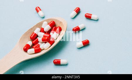 Red white pills wooden spoon Stock Photo