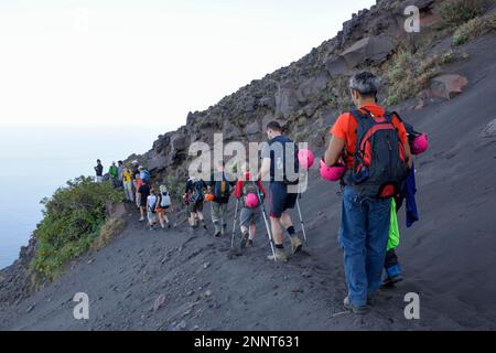 Tourists climbing in lava sand on the layer volcano Stromboli, island Stromboli, Liparic Islands, Italy Stock Photo