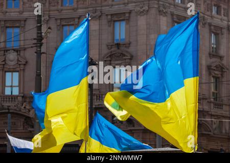 Flag with yellow and blue striped colors of Ukraine waving in the wind with a blue sky and sun. Stock Photo
