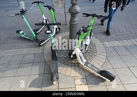 PRODUCTION - 09 February 2023, Hesse, Frankfurt/Main: E-scooters from various suppliers stand around a light pole on Opernplatz. Riding an e-scooter is a lot of fun, but the scooters continue to cause trouble. Strict specifications for the rental companies should provide a remedy. (to dpa 'Problems with the little speedsters - cities curb e-scooters') Photo: Arne Dedert/dpa Stock Photo