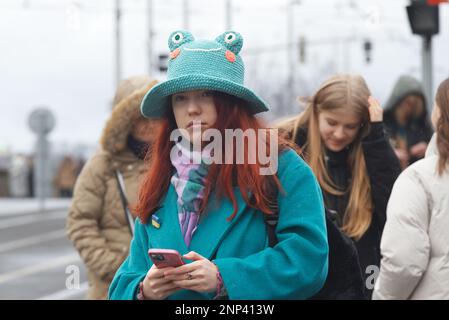 Prague - February 25: A young lady in turquoise with a badge in Ukrainian colours on the lapel of her coat on February 25, 2023 in Prague, Czech Repub Stock Photo