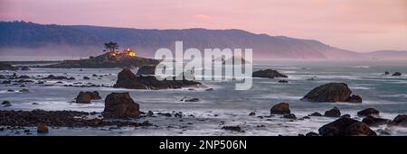 Distant view of lighthouse on island at sunset, Battery Point Lighthouse, Crescent City, California, USA Stock Photo