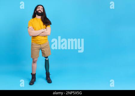 Cheerful man with a leg prosthesis standing with arms crossed Stock Photo