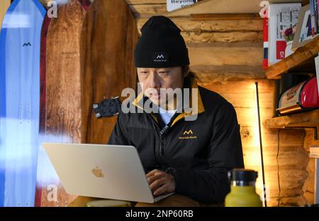 (230226) -- URUMQI, Feb. 26, 2023 (Xinhua) -- Peng Chao writes about skiing safety guidelines at his cabin in the village of Hemu in Altay, northwest China's Xinjiang Uygur Autonomous Region on Jan. 12, 2023. With its high-quality snow conditions, Xinjiang in northwest China has built a number of high-standard ski resorts and become a new hotspot for winter sports. The snow season in Altay, which is located in the northernmost part of Xinjiang, can last up to seven months, making it a heaven for winter sports lovers. At the beginning of the snow season in 2021, Beijing-based skier Peng Cha Stock Photo