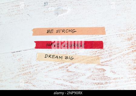 motivational message written on colorful washi tape against white wooden background Stock Photo