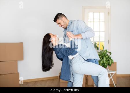 Romantic Young Spouses Dancing In Living Room Of Their New Flat Stock Photo