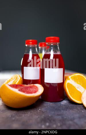 plastic bottles with a drink and various fruits on the background. Stock Photo