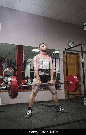 athlete doing deadlift in style sumo in gym Stock Photo