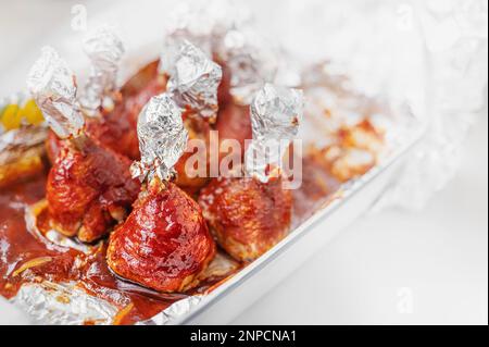 Chicken drumsticks in smoked paprika sauce baked under the grill. Chicken Drumstick candies. Stock Photo