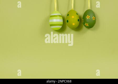 A row of painted multi-colored eggs in a row on a green background. Easter concept. Stock Photo
