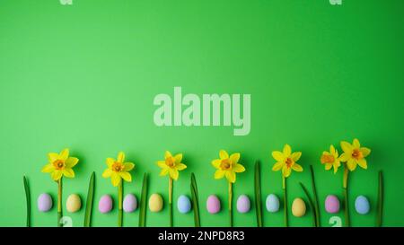 Yellow narcissus and easter eggs on green background. Spring, easter concept. Flat lay, top view, copy space. Stock Photo