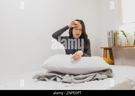 Asian female, young woman having cold, high temperature on bed Stock Photo