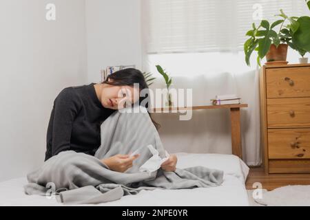 Asian female, young woman having cold, high temperature on bed Stock Photo