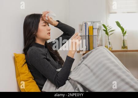 Asian female, young woman having cold, high temperature on bed Stock Photo