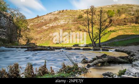Water seen flowing around and over some of the stepping stones at Dovedale after some heavy rainfall. Stock Photo