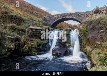 The River Dane flows under the packhorse bridge at Three Shires Head where the counties of Cheshire and Staffordshire and Derbyshire meet in the Peak District. Stock Photo