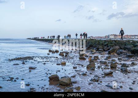 The tide goes out at West Kirby on the Wirral exposing the rocks which separate the sea with the Marine Lake. Stock Photo