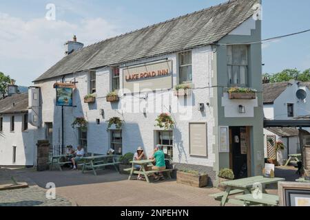 People relaxing outside the Lake Road Inn pub in the town centre in summer. Stock Photo