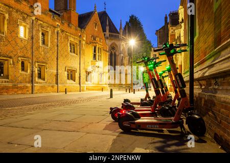 Electric Scooters parked in front of St John's College on Trinity Street in Cambridge city centre. Stock Photo