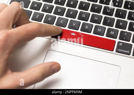 Online International Business concept: Computer key with the China flag on it. Male hand pressing computer key with China flag Stock Photo