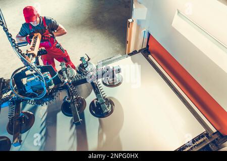 Caucasian Commercial Vacuum Suction Lift Operator Worker. Metalworking Industry Theme. Stock Photo