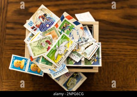 April 16 2019 - Calgary Alberta Canada - Box full of used postage stamps from around the world Stock Photo