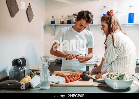 Young couple having fun in the kitchen in the morning, while preparing breakfast Stock Photo