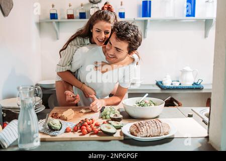 Young couple having fun in the kitchen in the morning, while preparing breakfast Stock Photo