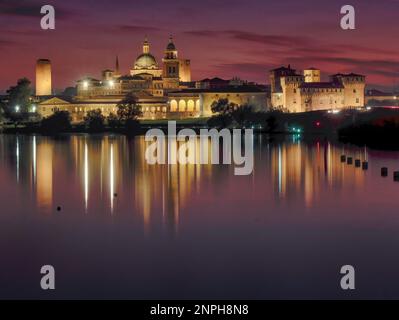 Skyline of the Renaissance city of Mantua at dusk with reflections in the water of the lake formed by the Mincio River. Stock Photo