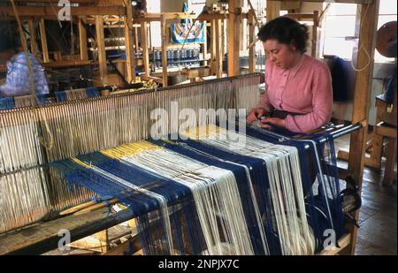 1960s, historical, inside an artisan workshop, at wooden frame loom, a lady sitting, weaving wool, Scotland, UK. Stock Photo