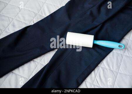 roller for cleaning clothes from dust and pellets on dark trousers, top view Stock Photo