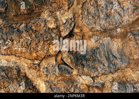 Old worn stone wall surface as background. Detail from the town of Lovran in Croatia. Stock Photo