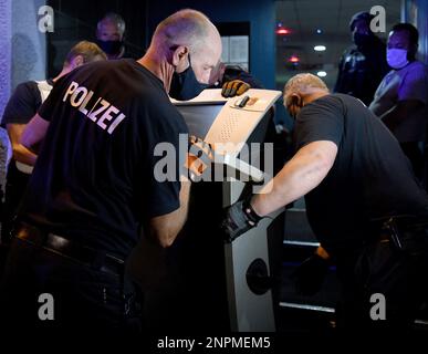 Police officers confiscate a slot machine during a raid in Essen, Germany, Saturday, Aug. 15, 2020. Hundreds of police officers searched shisha bars, tea houses and illegal gambling halls across western Germany early Sunday. The officers confiscated 34,000 euros ($40,260) in cash, 19 gambling machines and three kilograms (6.6 pounds) of shisha tobacco, the German news agency dpa reported. 11 stores were shut down because of violations against corona measures. (Caroline Seidel/dpa via AP)