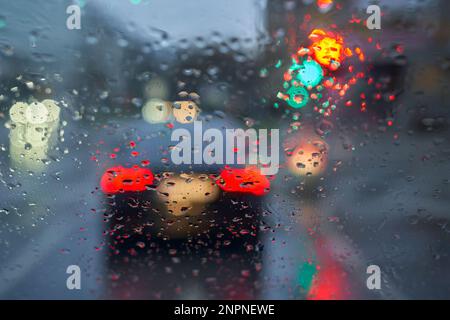 Driving in the rain. Drops on the windshield. Wet road. Stock Photo