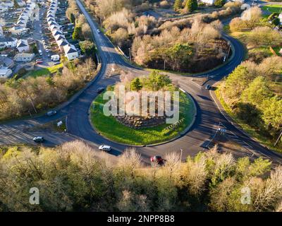 Traffic roundabout on a small road surrounded by trees displaying ...