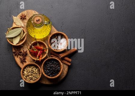 Various dried spices and olive oil on wooden board Stock Photo