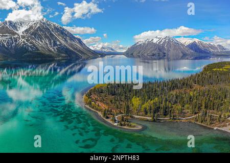 Stunning wilderness lake views in northern Canada during summer time. Snow capped mountains and incredible nature landscape. Stock Photo